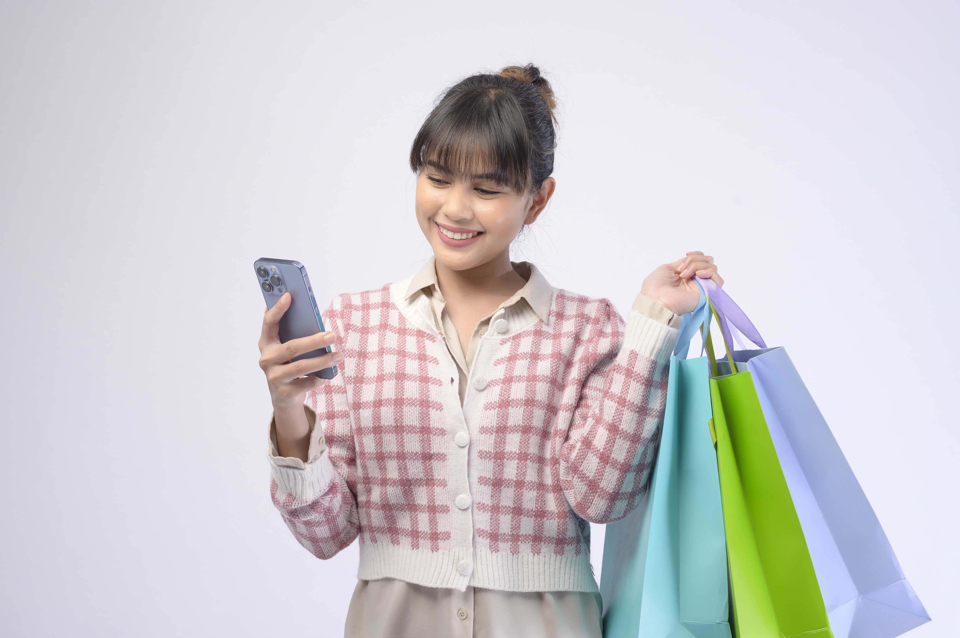 Attractive shopper woman holding shopping bags over white background voice commerce